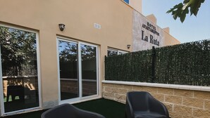 A hotel patio with outdoor seating and a view of the building. - Hotel Apartamento La Ruta (Calpe)