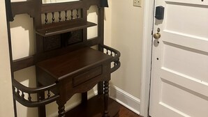 Un banc en bois, avec un miroir et une porte dotée d’une fenêtre.