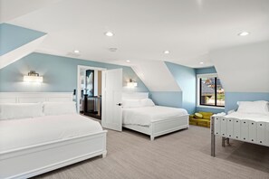 Two comfortable beds with matching headboards in a cozy room with a sloped ceiling.