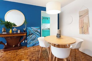 A room with a round wooden table, white chairs, a mirror, and a painting. - Cute apartment in Condesa (Ciudad de México)