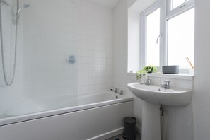 Un bagno moderno con vasca, lavandino e finestra.