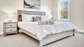 A bedroom with a bed, nightstands, a window, and a painting on the wall. - Lakefront Moose Pond Retreat (Denmark)