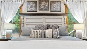 Una camera da letto con un letto grande, una testiera in legno e tre stampe floreali incorniciate sopra il letto.