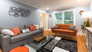 A living room with two sofas, a coffee table, and a wall art piece. - Modern Luxury w/ Pool Table 3BR/5BD Sleeps 10 (Decatur)