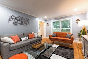 A living room with two sofas, a coffee table, and a wall art piece.