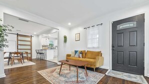 Een moderne woonkamer met een bank, salontafel en eethoek.