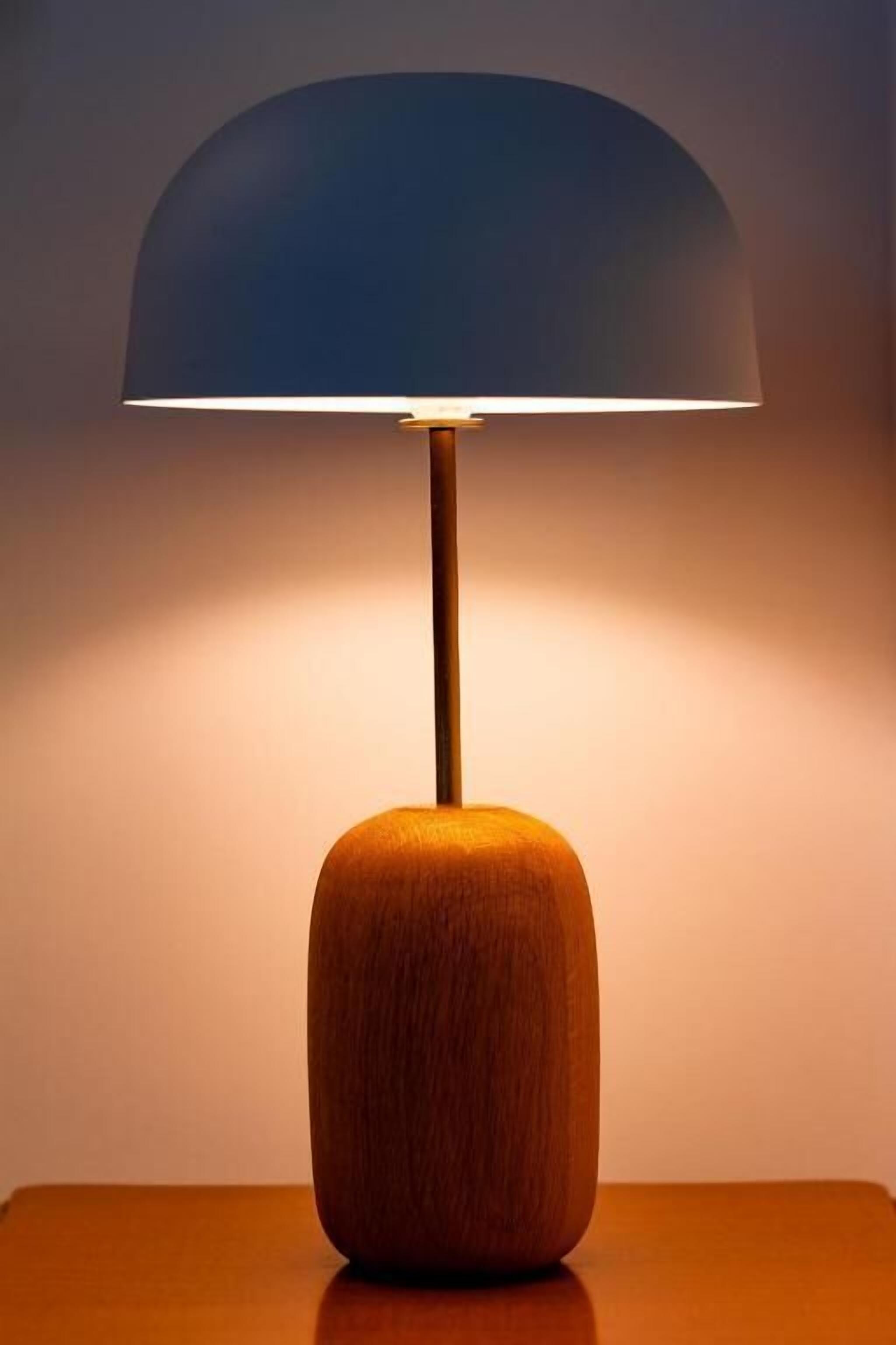A table lamp with a wooden base and a dome-shaped lampshade.