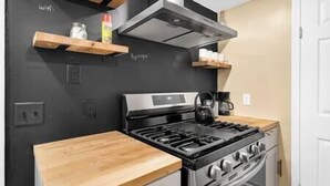 A kitchen with a gas stove, oven, and a coffee maker on the counter. - Ranch near gordyville, sports complex, 13 miles from hospitals (Rantoul)