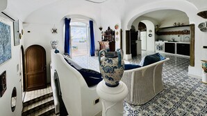 A spacious living area with a view to the outside, a dining area with a table and chairs, and a kitchen with modern appliances. - YourHome - Assia House Praiano (Praiano)
