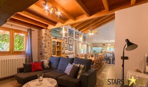 A cozy living room with a sofa, a coffee table, and a dining area in the background.