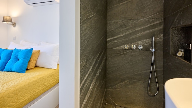 Ein modernes Hotelzimmer mit Bett, Dusche und Badezimmer.
