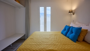 Ein Zimmer mit Bett, Sitzbank, Fenster und Klimaanlage.