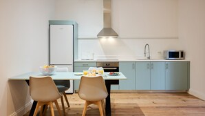 Une cuisine moderne équipée d’une table à manger, de chaises, d’un four à micro-ondes et d’un réfrigérateur.