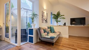 Un salon moderne avec un canapé, un téléviseur et des plantes en pot.
