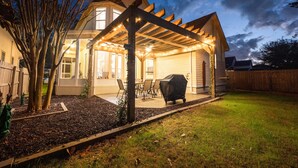 A house with a covered patio, a barbecue grill, and a well-maintained lawn. - Lei'd Back * Golf Cart Included & Pet Friendly * Salt Water Vacations (Destin)