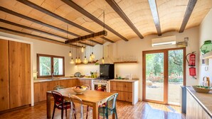 A modern kitchen with wooden cabinets, a central island, and hanging pendant lights. - Camadix, Finca 5StarsHome Mallorca (Costitx)