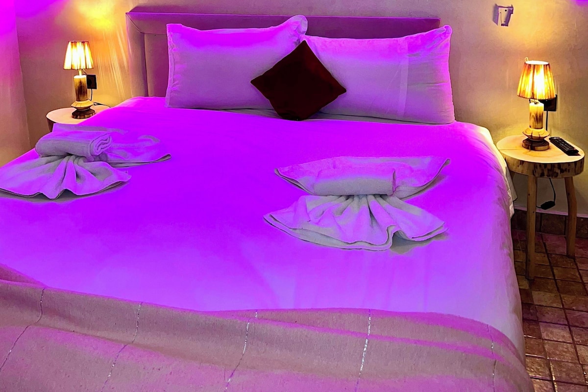 A bed with a headboard, two bedside tables, and a wall with a decorative arch.