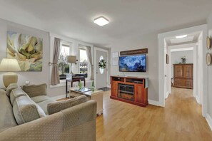 Una sala de estar con sofá, televisión, chimenea y comedor.