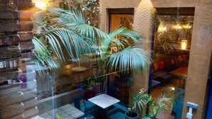 A courtyard with potted plants, a table, and a hanging lamp. - Hotel Lincoln Lounge (Barcelona)