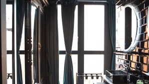 A modern kitchen with a black countertop, a wooden cabinet, and a large window with curtains. - Hotel Lincoln Lounge (Barcelona)