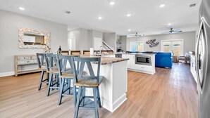 Une cuisine spacieuse avec un îlot central, des chaises en bois et une table à manger.