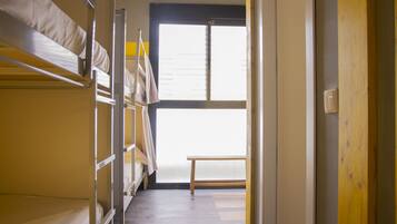 Un dormitorio con literas y una ventana.