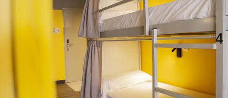 A bunk bed room with a door and a number on the wall.