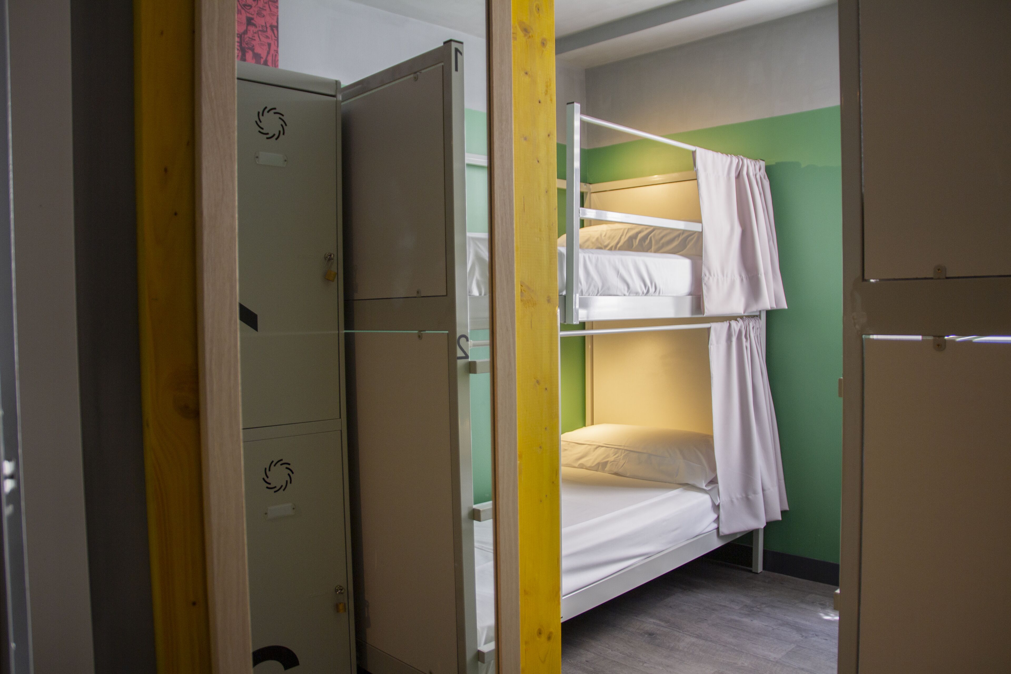 Un dormitorio con literas, un armario y una puerta.