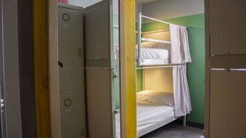 Un dormitorio con literas, un armario y una puerta.