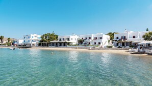 Eine Küstenstadt mit weißen Häusern, klarem, blauem Wasser und einem Sandstrand.