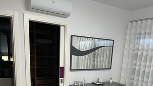 Une chambre à coucher moderne avec un lit, une commode, un miroir et un dressing.