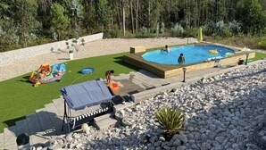 Un jardin avec une piscine, une pelouse et un espace salon abrité.
