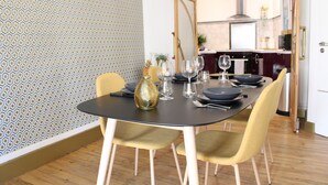 A dining area with a round table set for six, surrounded by four chairs.