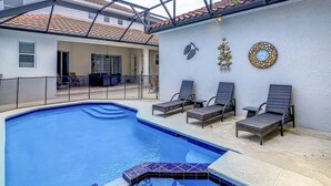 En swimmingpool med liggestole og en overdækket terrasse.