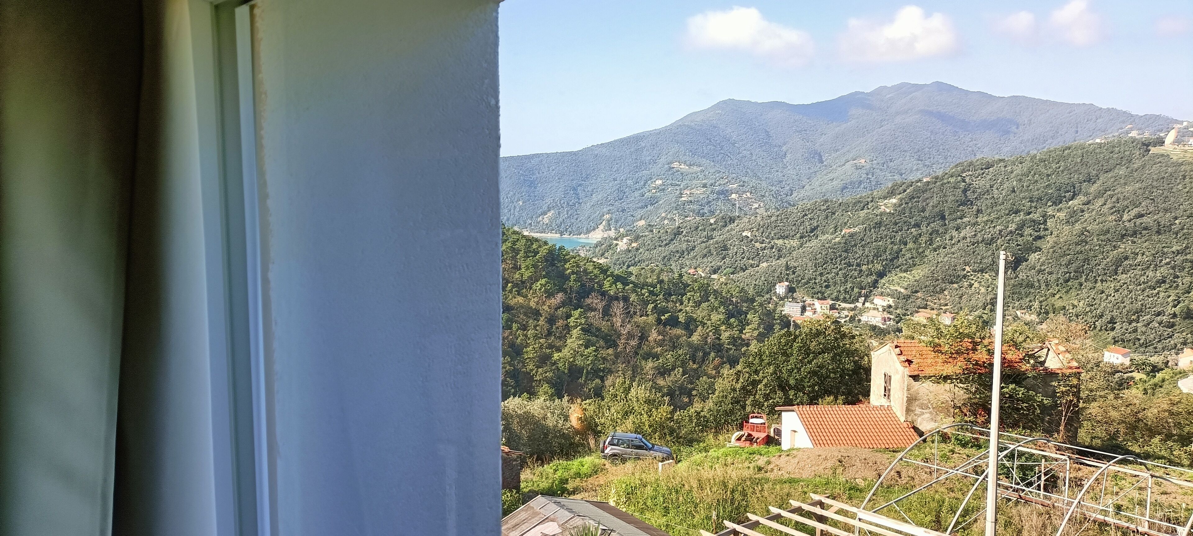 Un paysage montagneux avec vue sur un lac et quelques bâtiments dispersés.