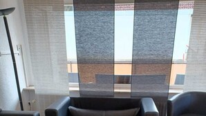 A modern living room with a sofa, a recliner, and a flat-screen TV. - Ferienwohnung Schwarzwaldsegen mit Balkon (Todtmoos)
