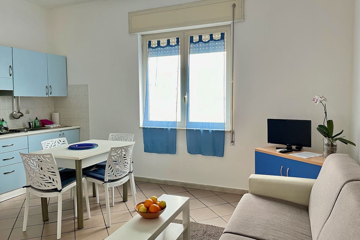 A compact living space with a dining area, kitchenette, and seating area.