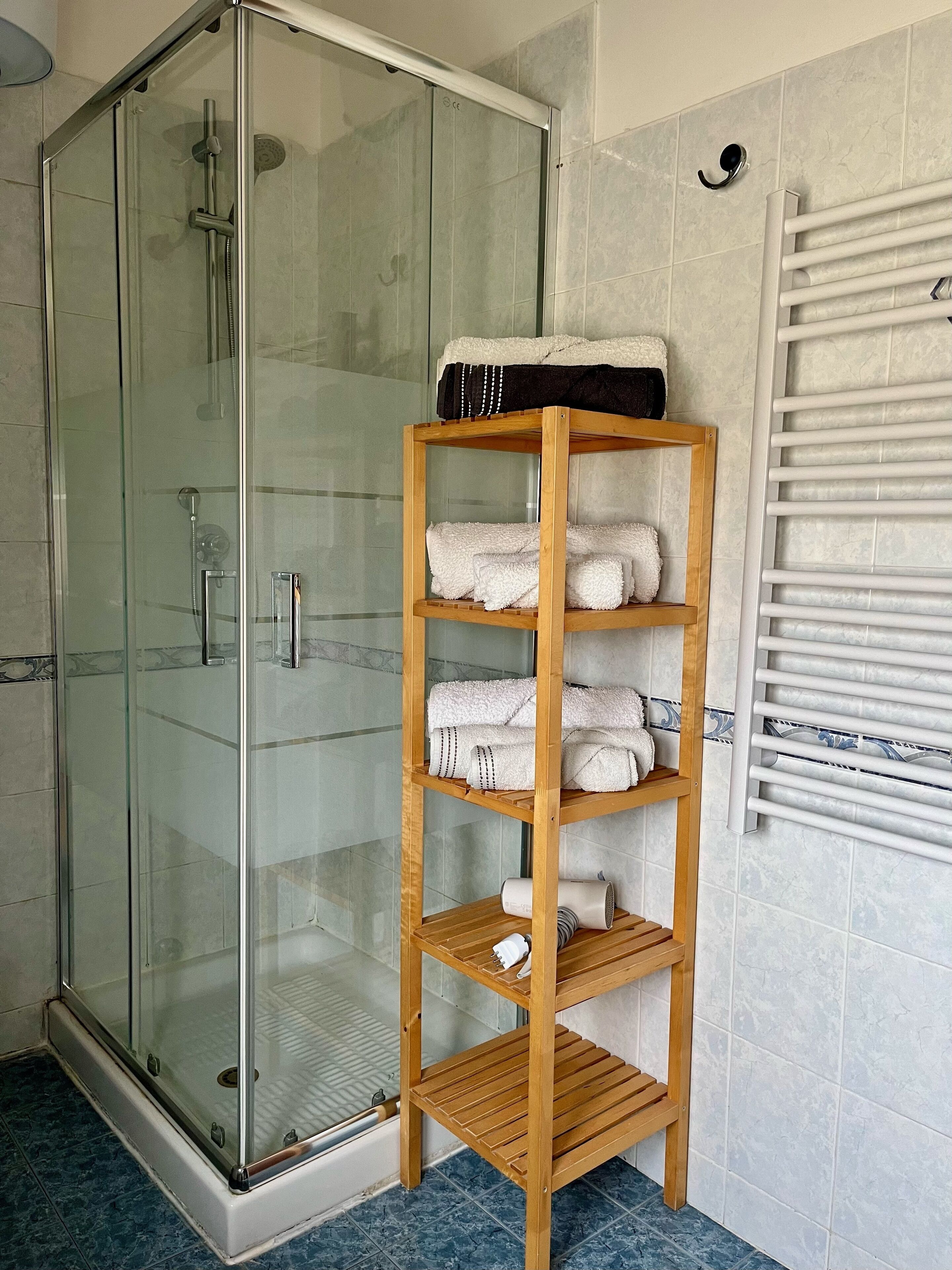 Eenvoudig appartement | Badkamer | Een douche, een haardroger, een bidet, toiletpapier