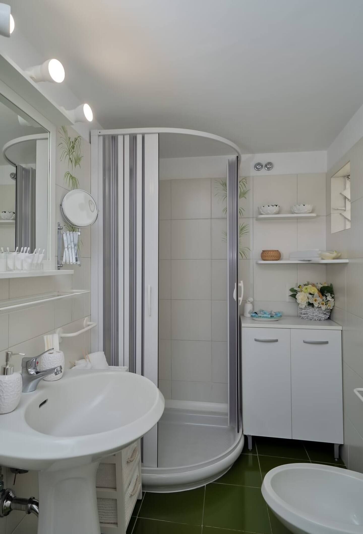 A modern bathroom with a shower, two sinks, a mirror, and shelves with toiletries.