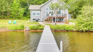 Una casa con un muelle que da a un cuerpo de agua, rodeada de vegetación.