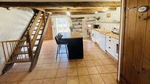 A kitchen with a wooden staircase, a dining area, and a washing machine. - Family friendly gîte set in idyllic countryside w/games barn + 12x6m pool (La Chapelle pouilloux)