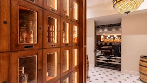 A wooden cabinet with glass doors, a checkered floor, and a bar area in the background. - 2 Bedroom Suite (Frankfort)