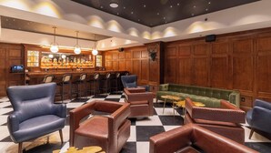 A bar area with wooden paneling, leather chairs, and a checkered floor. - 2 Bedroom Suite (Frankfort)