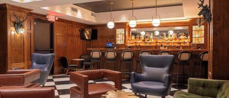 A bar area with leather chairs, a checkered floor, and a bar stocked with bottles.