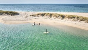 Ein Strand mit klarem türkisfarbenem Wasser und einem Sandstrand.