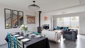 A modern living room with a dining area, a sofa set, a TV, and a fireplace. - Rosamaris - Maison pour 8 avec jardin (Saint-Malo)