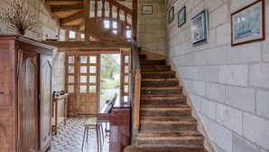 Una scala in legno con pavimento a scacchi che conduce a una porta.