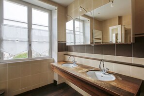 Un bagno con due lavandini, uno specchio grande e una finestra.