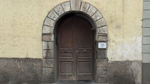 A large, dark wooden door with a stone archway, set in a building with a yellow and grey facade. - BEAUTY HOME SORRENTO (Sorrento)
