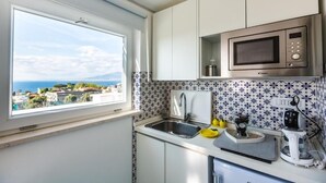 A kitchen with a view of the sea, a microwave, a sink, and a coffee maker. - BEAUTY HOME SORRENTO (Sorrento)
